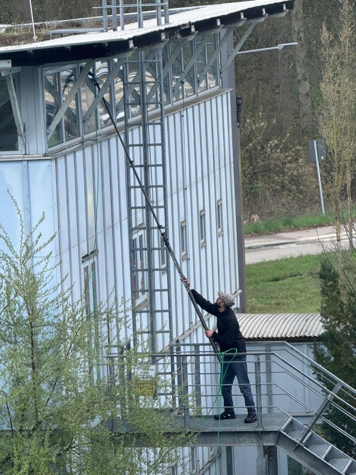 Fassadenreinigung mit Teleskopstange an einem mehrgeschossigen Gewerbegebäude